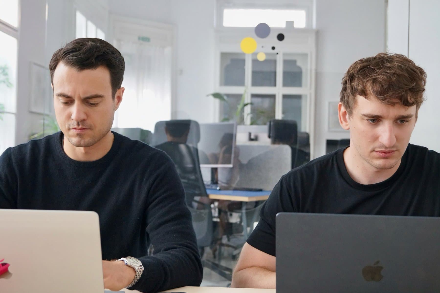 Torben Lange and Johannes Freyer working side by side on their laptops in the office